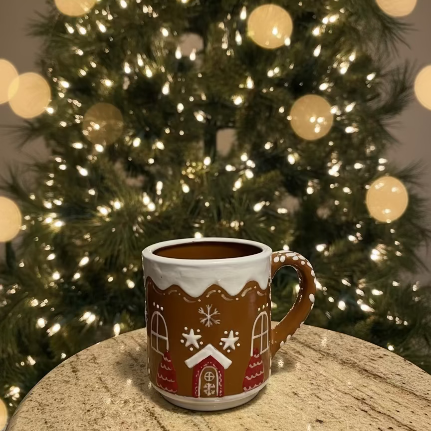 Gingerbread-themed mug on a granite countertop with a tiled backsplash.