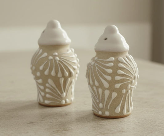 Two ceramic jars with white patterns on a neutral background