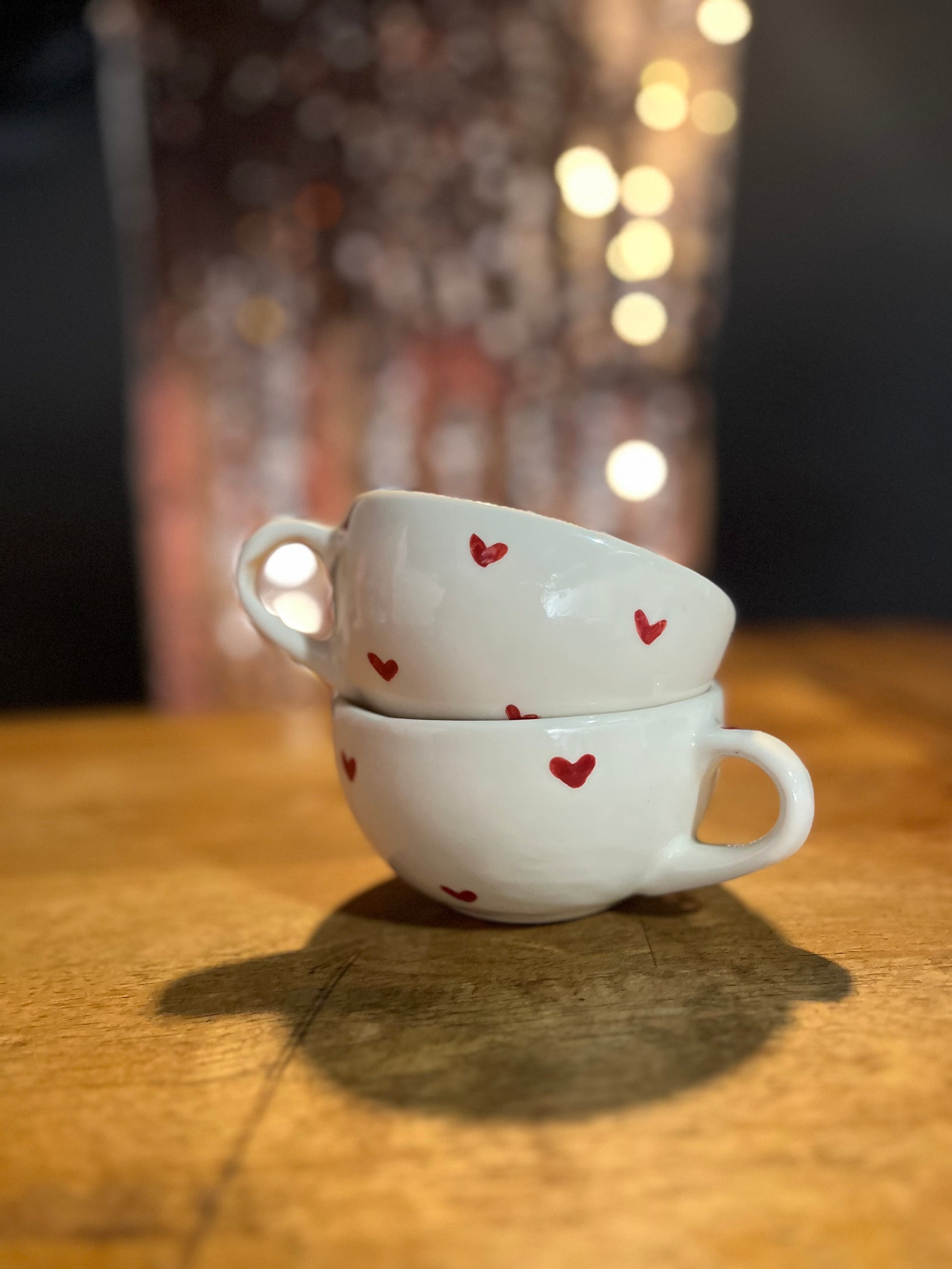 cup adorned with vibrant red hearts. The design is playful and fun, perfect for a romantic gesture or as a charming gift. Ideal for sipping your favorite beverage while adding a touch of love and sweetness to your day. <3