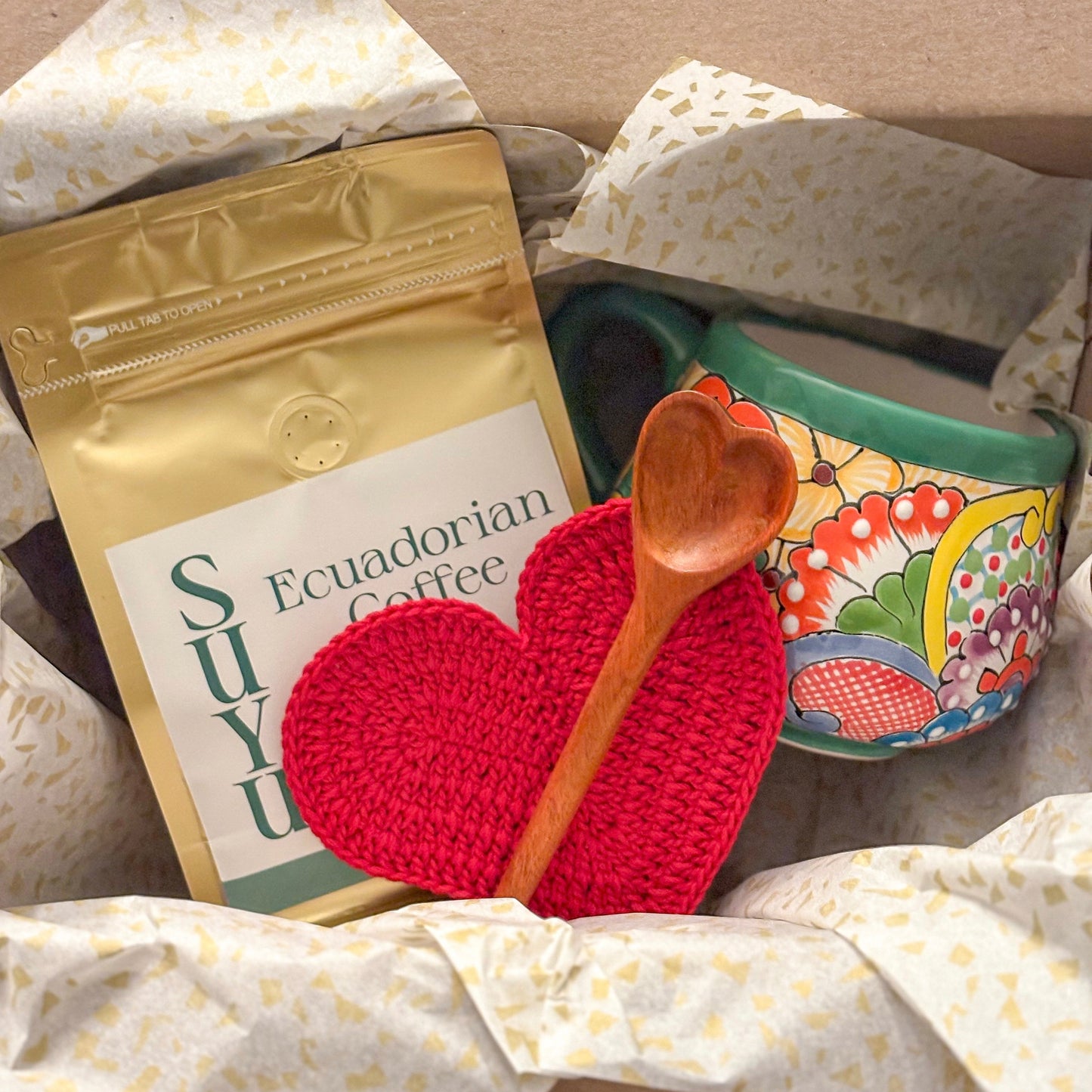 Ecuadorian coffee package, wooden spoon, and decorative heart on a patterned surface