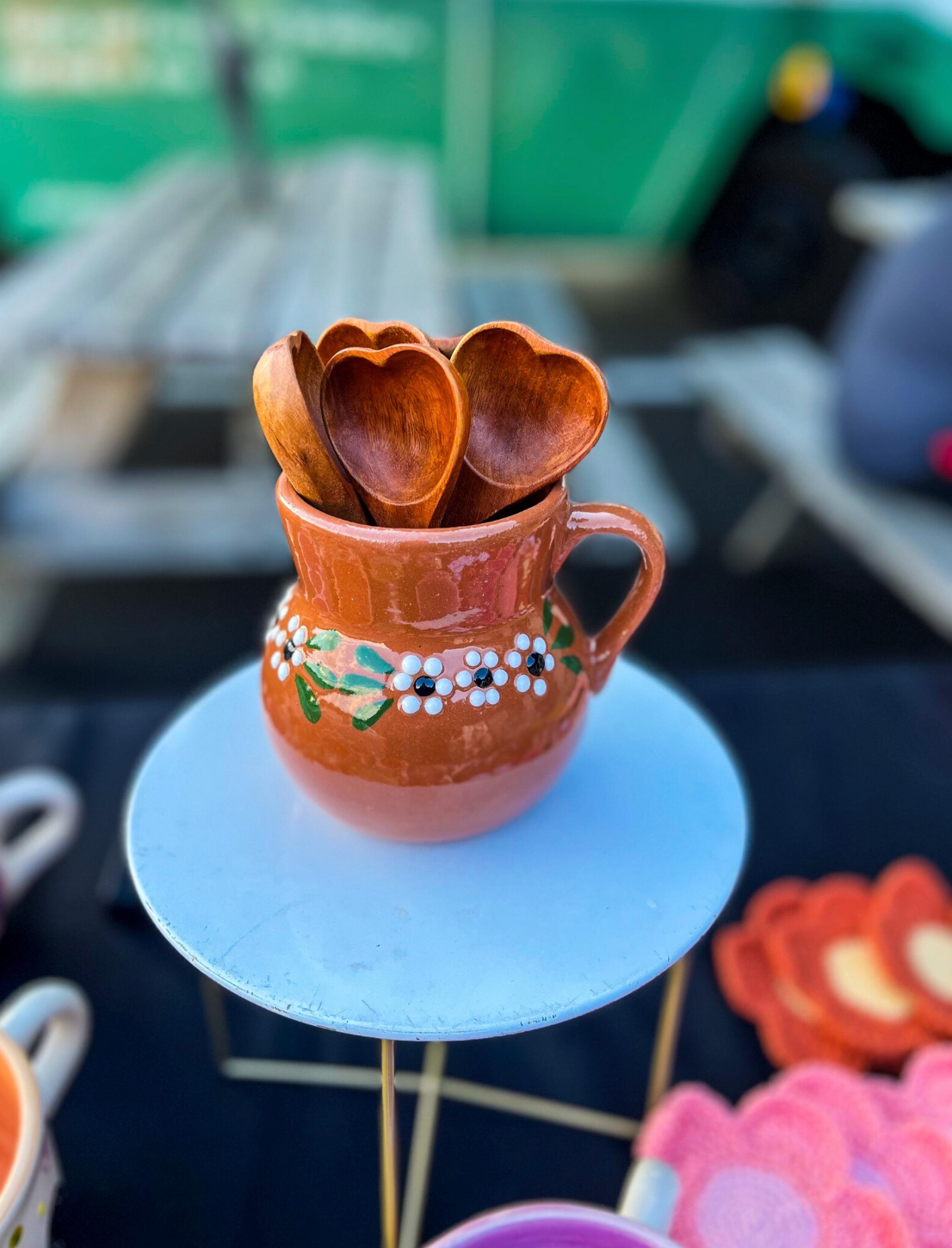 Decorative ceramicmugwith wooden spoons on a small round table.