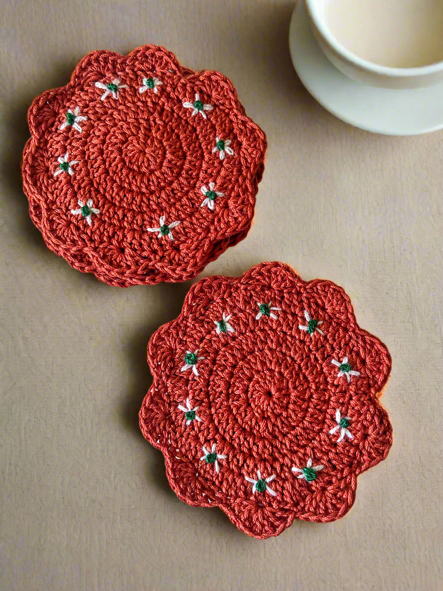 Two  crocheted coasters with floral patterns on a white textured surface