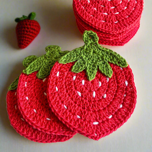 Crocheted strawberry coasters with green leaves on a light background