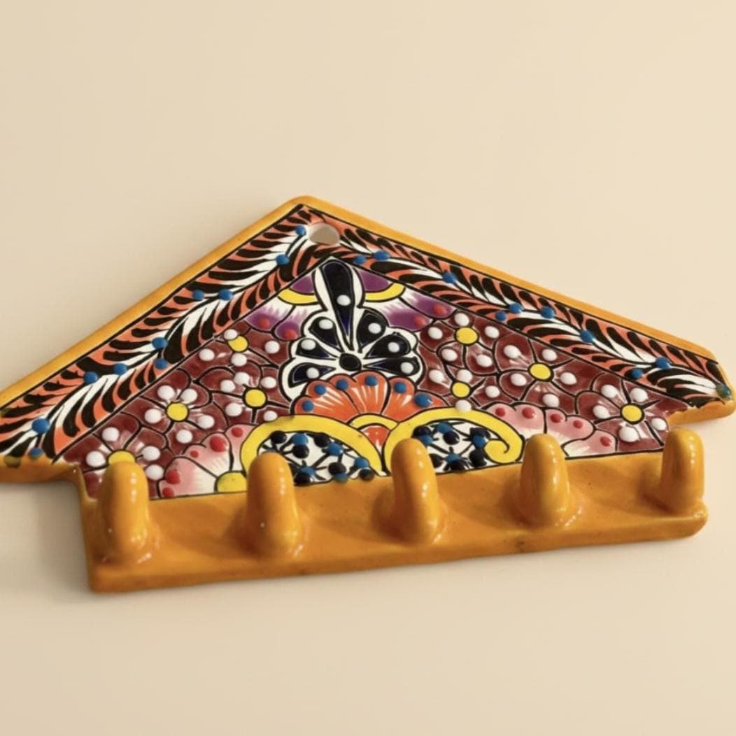 Decorative key holder with colorful floral patterns on a beige background